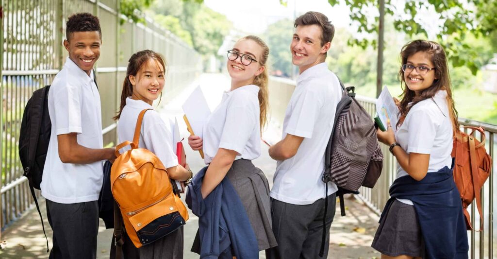 Five happy students looking back over their shoulders