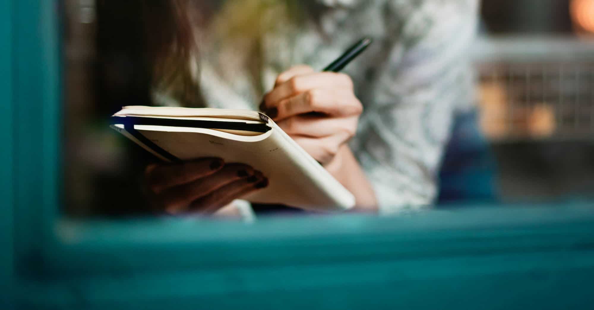 Closeup of woman writing in notebook