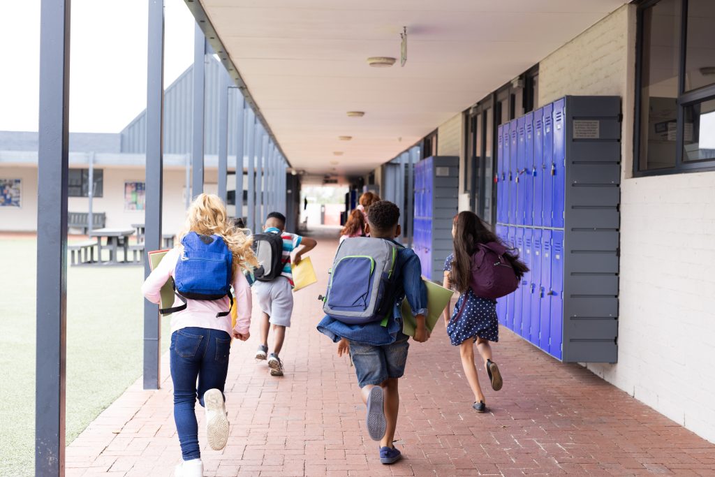 High school students running excitedly toward school