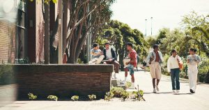 Student walking across a college with friends